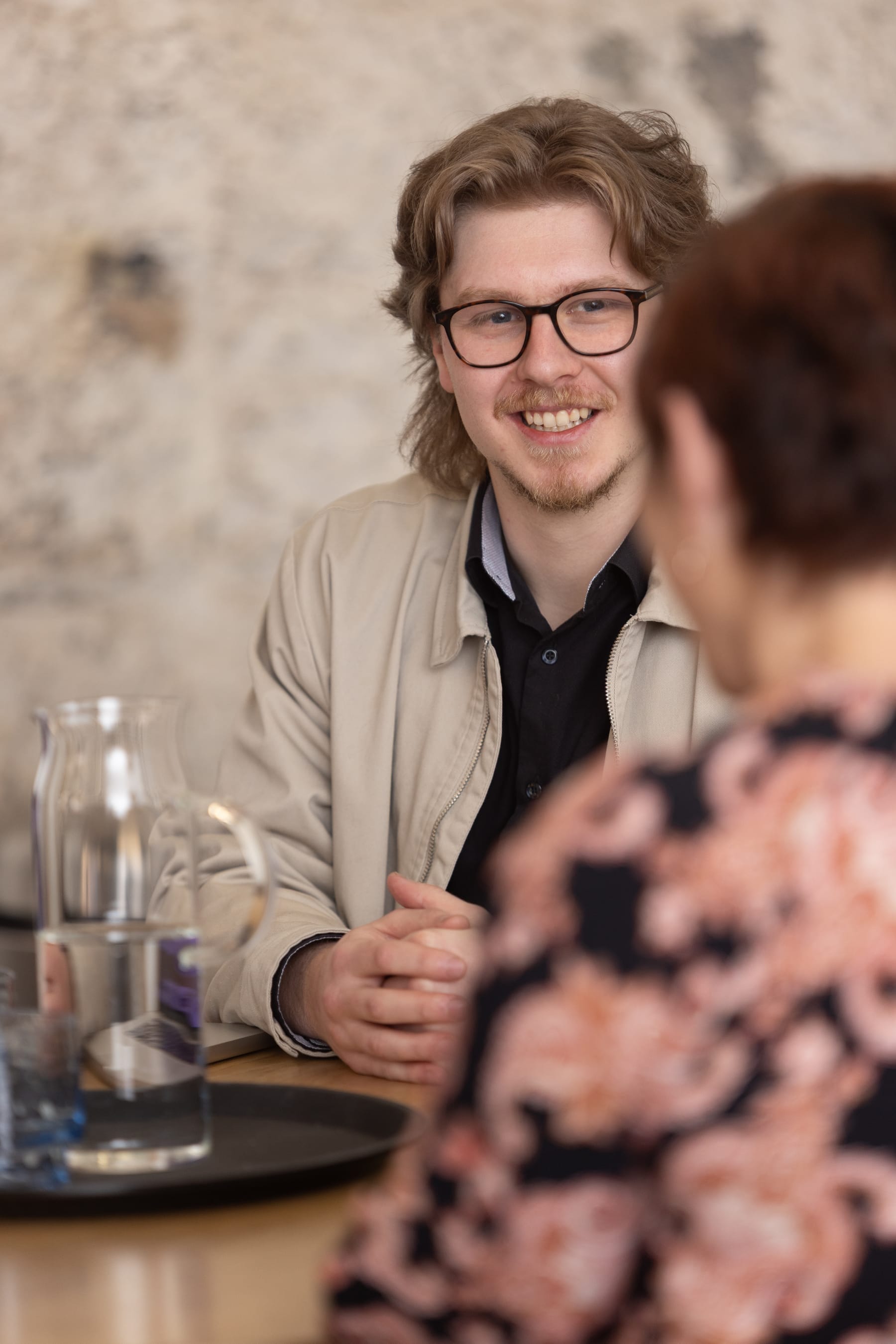 Nick sits at a deak with a client in a meeting in the fireband studio